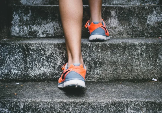 Legs in orange sneakers climbing concrete steps
